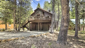 A two-story wooden cabin with a balcony, surrounded by trees. - Game Room: Mountain Chalet 5 Mi to Donner Lake (Truckee)