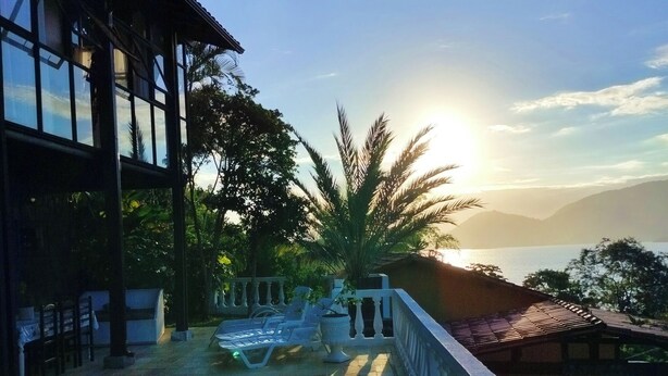 Una piscina con vistas a las montañas y al atardecer.