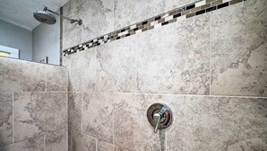 A bathroom with a shower, tiled walls, and a visible showerhead. - Well-equipped Cody Cottage: 2 Mi to Cody Rodeo! (Cody)