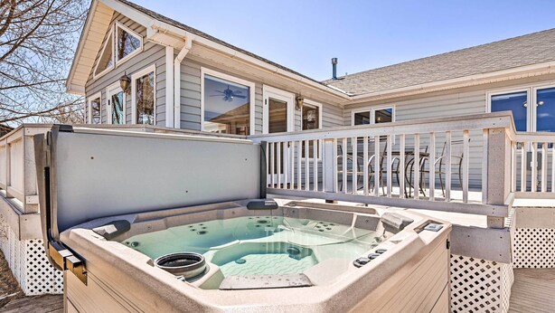 A hot tub with a glass enclosure, a wooden deck, and a house in the background. - Charming Buena Vista Home w/ Hot Tub + Deck! (Buena Vista)