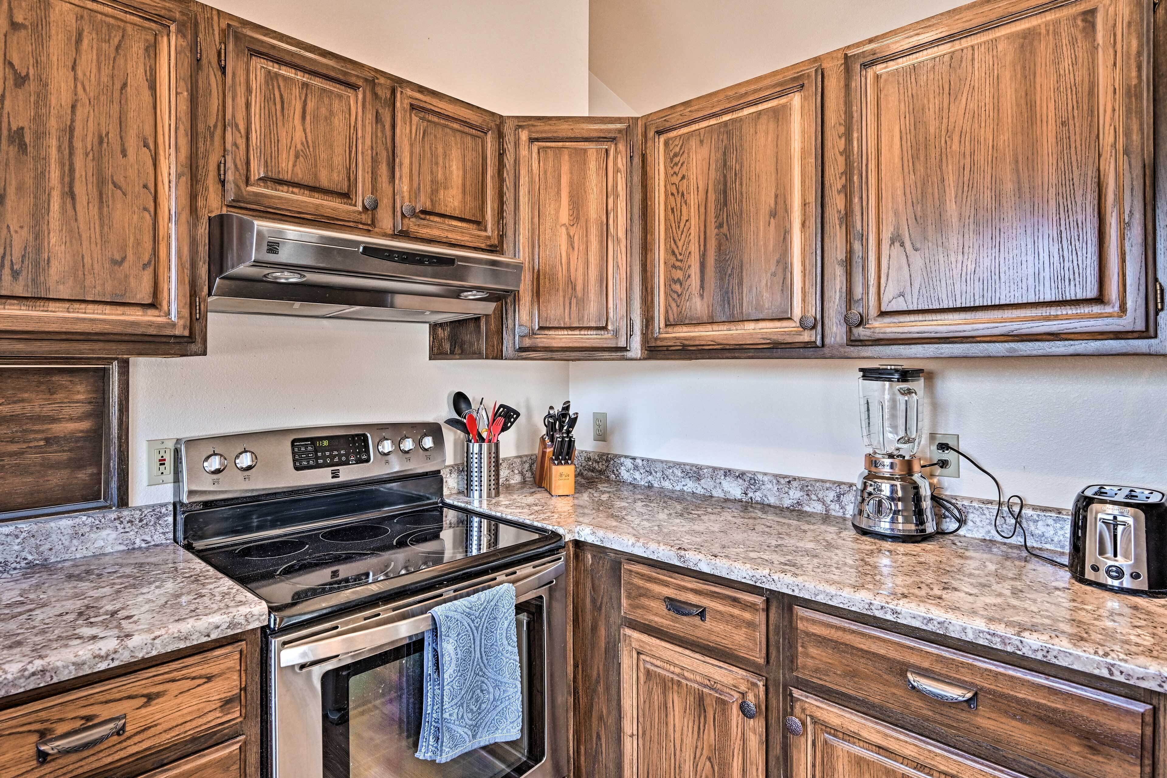 A kitchen with wooden cabinets, a stainless steel range, a built-in oven, a coffee maker, and a toaster.