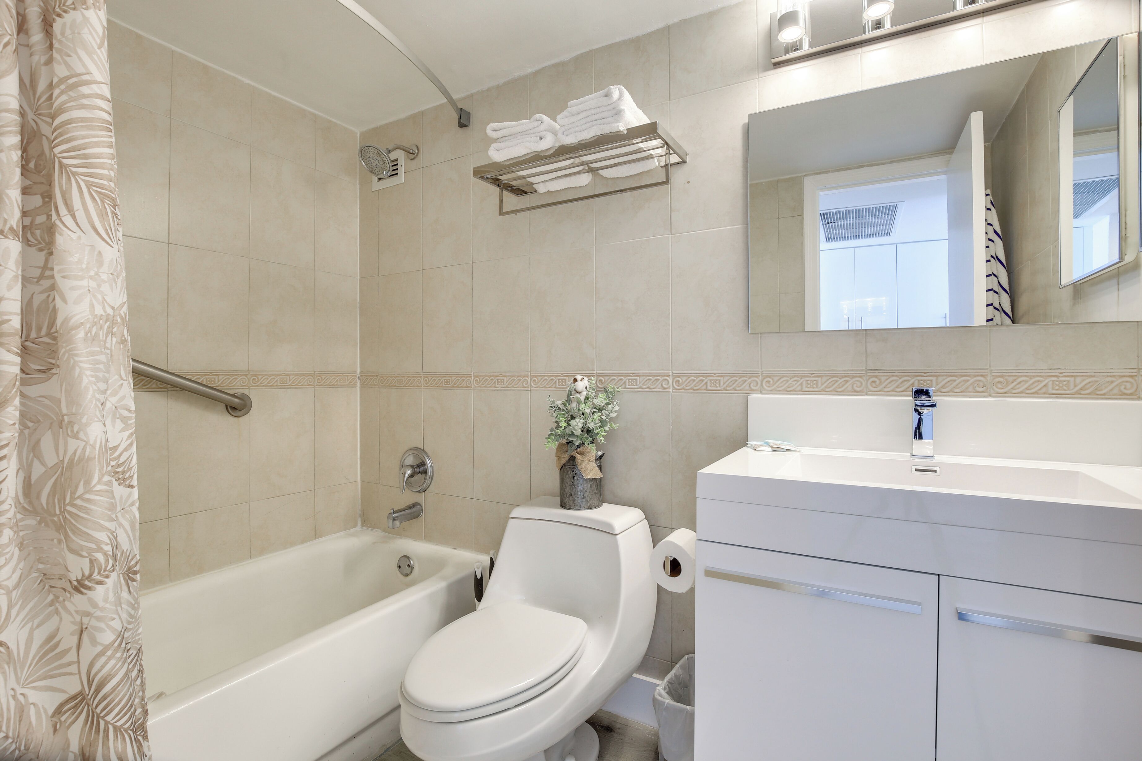 Une salle de bain moderne avec une baignoire, des toilettes et un meuble-lavabo.