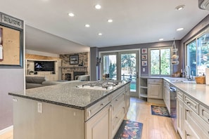 A modern kitchen with a large island, built-in appliances, and a view to the outdoors. - Near Shops & Eats! Centennial Escape w/ Sunroom (Englewood)