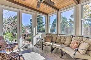 A sunroom with a sofa and chairs, large windows, and a wooden ceiling. - Near Shops & Eats! Centennial Escape w/ Sunroom (Englewood)