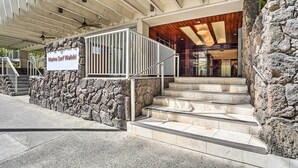 A stone-clad building entrance with a sign reading "Marine Surf Waikiki." - Centrally Located Vacation Rental in Waikiki! (Honolulu)