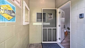 A hallway with a door leading to a room. There are signs on the wall, including one that says "Gone to the Beach" and another that says "Exodus Summer."
