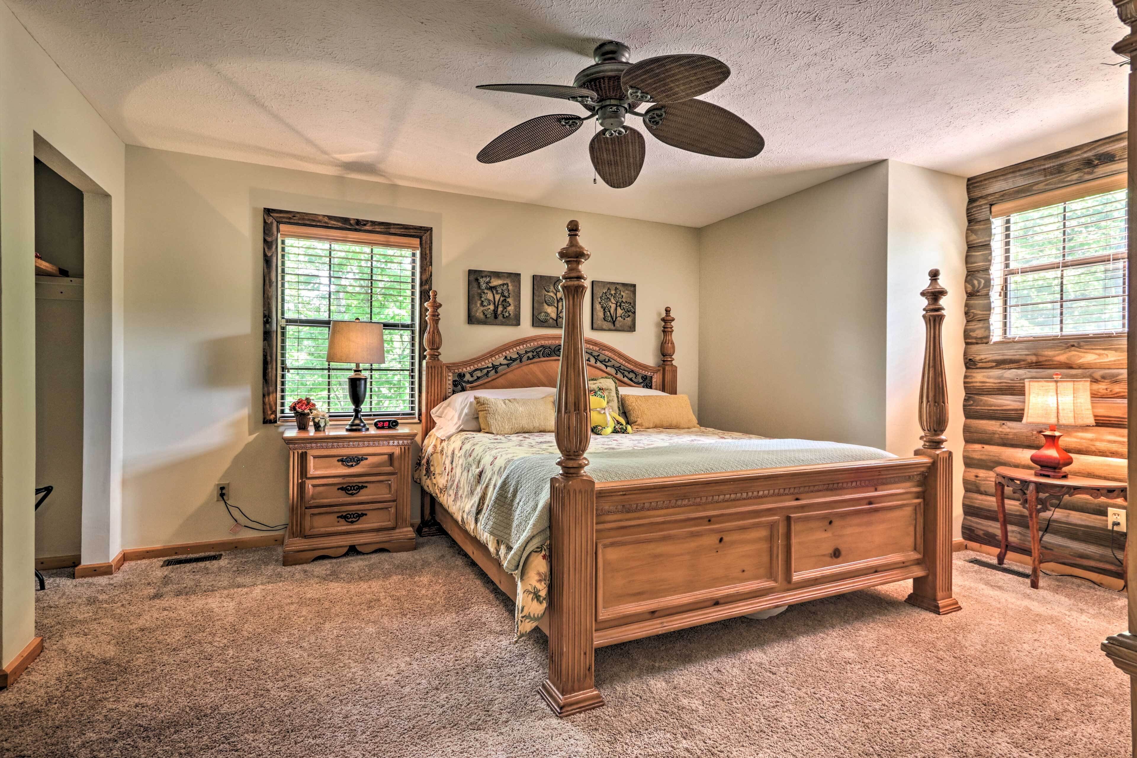 Une chambre à coucher avec un lit à baldaquin en bois, un ventilateur de plafond, une table de chevet avec une lampe et une fenêtre avec des stores.