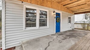 A covered porch with a wooden ceiling, a blue door with a wreath, and a concrete floor. - Charming Atlanta Vacation Home ~ 5 Mi to Dtwn (Atlanta)