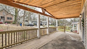 A covered porch with a wooden deck, white columns, and a railing. - Charming Atlanta Vacation Home ~ 5 Mi to Dtwn (Atlanta)