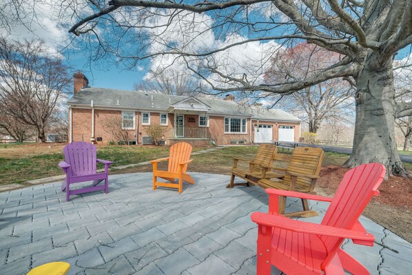 A brick building with a porch and outdoor seating area with Adirondack chairs. - Nature Getaway w/ On-site Trails, 17 Mi to DC! (Brookeville)