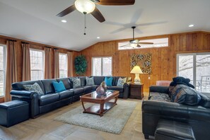 A spacious living room with a large sectional sofa, a coffee table, and a ceiling fan. - Nature Getaway w/ On-site Trails, 17 Mi to DC! (Brookeville)