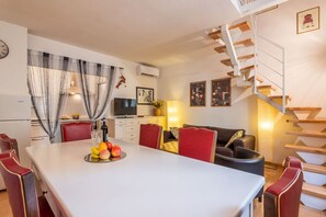 A modern interior with a dining area, a staircase, and a living room.