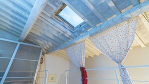 A room with a skylight, a window, and a curtain with a floral pattern. - Modern Murate View in Florence by Mmega (Firenze)
