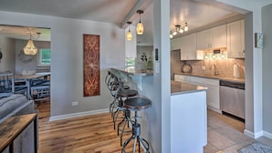 A modern kitchen with white cabinets, stainless steel appliances, and pendant lighting. - Fenced Yard + Patio: Pet-friendly Denver Home Base (Arvada)