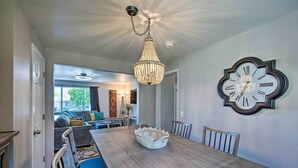 A dining area with a wooden table, chairs, and a chandelier. - Fenced Yard + Patio: Pet-friendly Denver Home Base (Arvada)