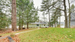 A house surrounded by trees with a path leading to the front door. - Falmouth Vacation Rental On Highland Lake! (Falmouth)