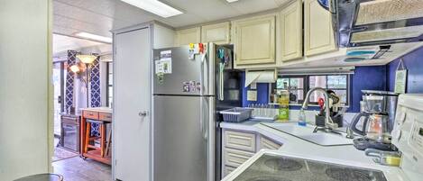 Une cuisine compacte équipée d’un réfrigérateur, d’une cuisinière, d’un four à micro-ondes et d’un évier.