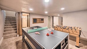 A room with a ping pong table, a foosball table, and a staircase. - Colorado Springs Home: Game Room, 3 Mi to Downtown (Colorado Springs)