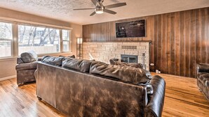 A living room with a large sectional sofa, a fireplace, and a ceiling fan. - Colorado Springs Home: Game Room, 3 Mi to Downtown (Colorado Springs)