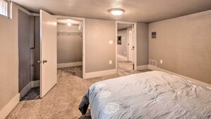 A bedroom with a bed, carpeted floor, and a closet. - Colorado Springs Home: Game Room, 3 Mi to Downtown (Colorado Springs)