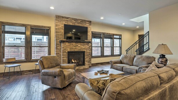 A living room with leather sofas, a fireplace, and large windows. - 1/2 Mi to Dtwn: Golden Gem w/ Patios! (Golden)
