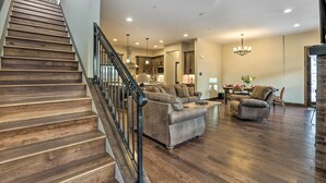 A spacious living area with a wooden staircase, a sofa set, and a dining table. - 1/2 Mi to Dtwn: Golden Gem w/ Patios! (Golden)