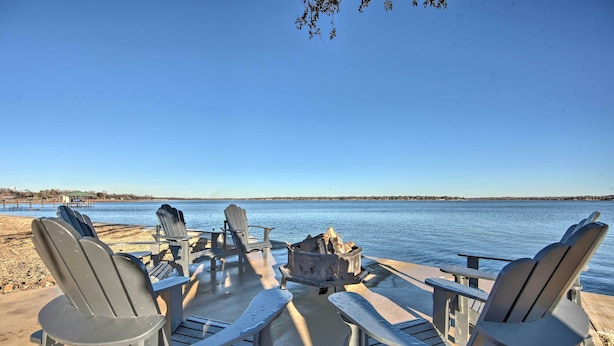 A deck with Adirondack chairs and a fire pit overlooking a calm body of water. - Lakefront Gun Barrel City Home w/ 5 Acres! (Mabank)