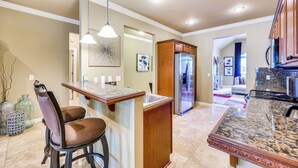 A kitchen with a central island, stainless steel appliances, and pendant lighting.