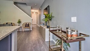 A modern kitchen with a granite countertop, a dining area with a wooden table, and a hallway leading to another room.