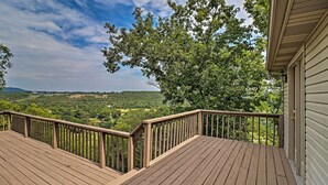Une terrasse en bois offrant une vue sur un paysage boisé.