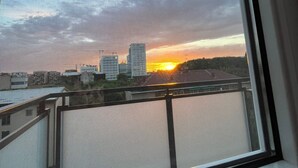 Vista des d'una finestra amb una ciutat al capvespre, edifici i un riu.