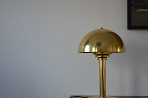 A brass desk lamp with a dome-shaped shade.