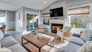 Una sala de estar moderna con chimenea, asientos cómodos y televisor.