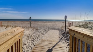 Un muelle de madera que conduce a una playa con cielo despejado.
