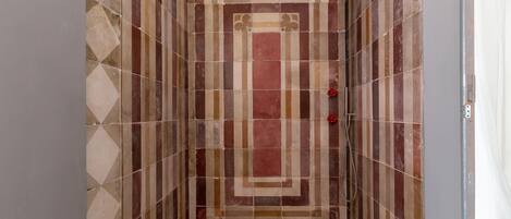 Ducha con pared de azulejos con un diseño geométrico.