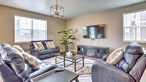 A living room with leather sofas, a coffee table, a TV, and a fireplace. - 10 Mi to Dia: Spacious Aurora House w/ Yard! (Aurora)
