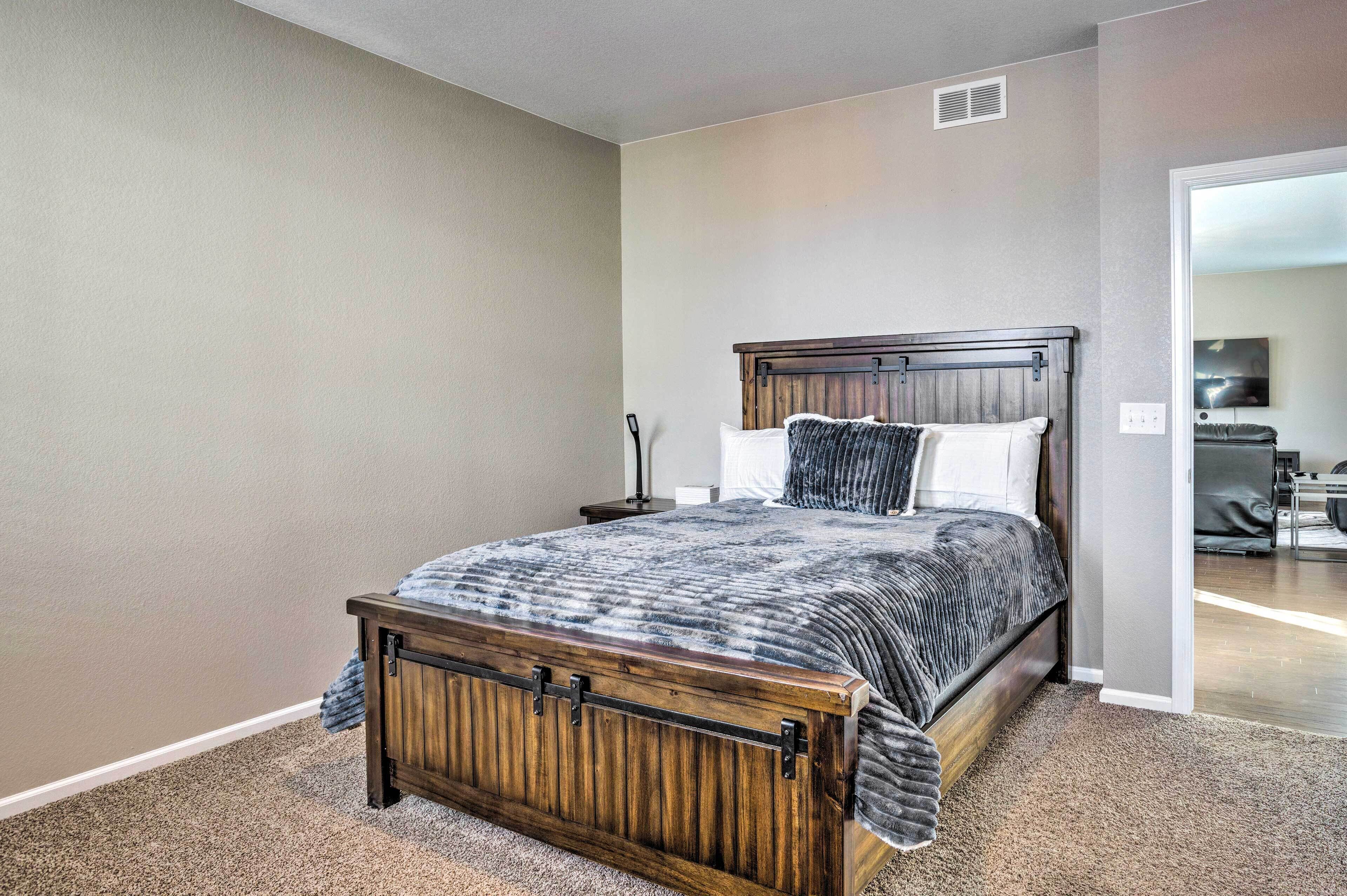 A bedroom with a wooden bed frame, a nightstand, and a lamp.