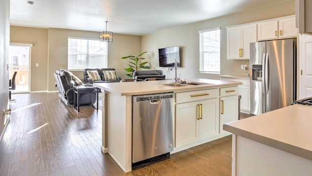 A modern kitchen with white cabinets, stainless steel appliances, and a dishwasher. - 10 Mi to Dia: Spacious Aurora House w/ Yard! (Aurora)
