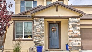 A two-story house with a stone facade, a blue front door, and a welcome sign. - Air Racing Decor, Hot Tub: Sparks Home! (Sparks)