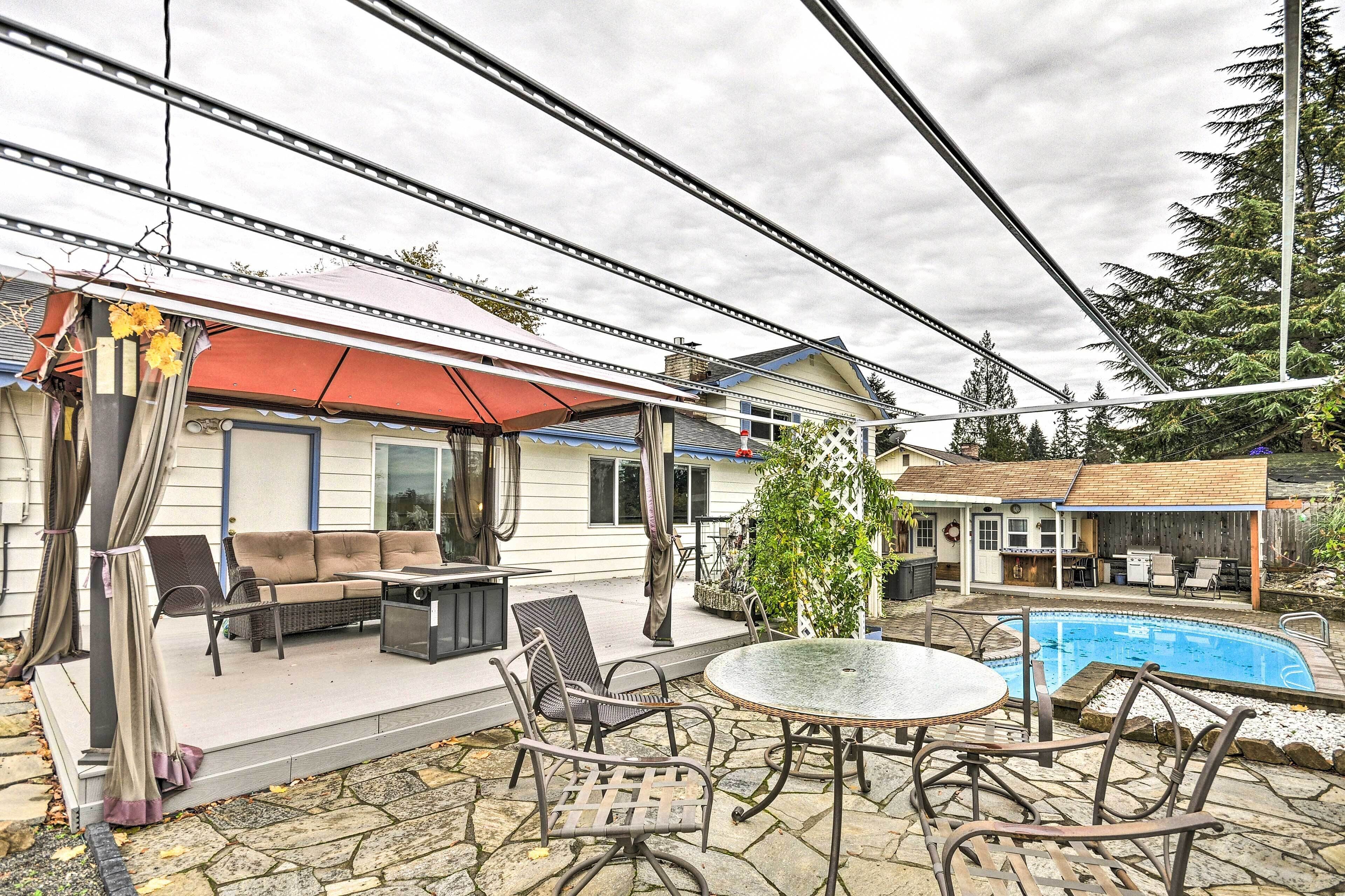 A patio with outdoor furniture, a pool, and a covered area with a red awning.
