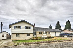 A two-story house with a garage, a front yard with a fountain, and a truck parked in the driveway.