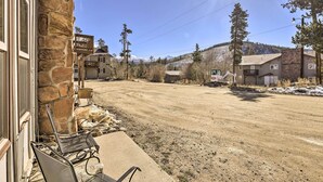 A rustic building with stone walls, a dirt road, and a mountainous backdrop. - Quaint Winter Park Townhouse < 5 Mi to Ski! (Winter Park)