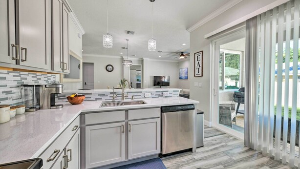 A modern kitchen with white cabinets, stainless steel appliances, and pendant lighting. - Beautiful Getaway ~ 4 Miles to Venice Beach! (Venice)