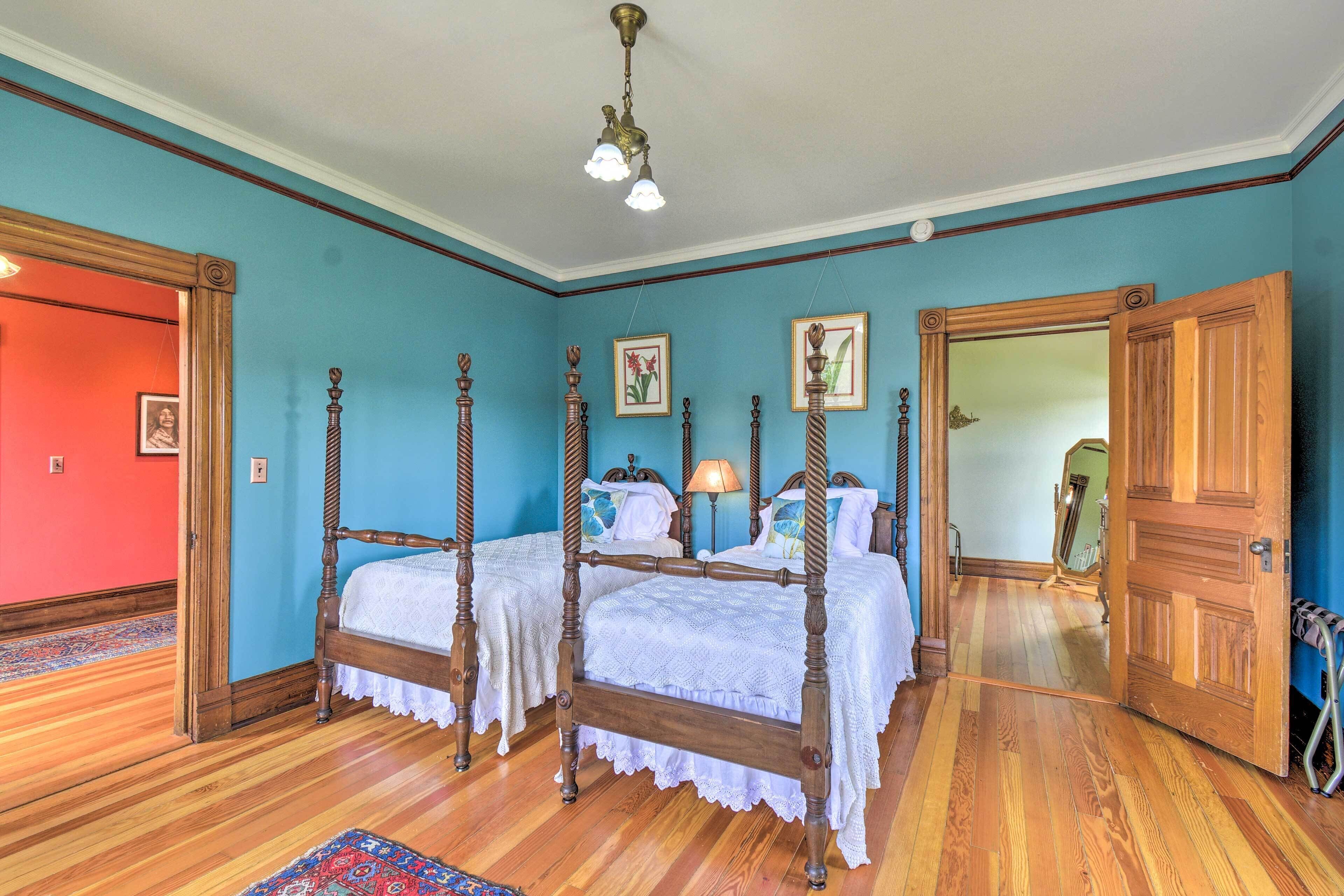 Une chambre à coucher avec un lit à baldaquin, un plancher en bois et un mur bleu.