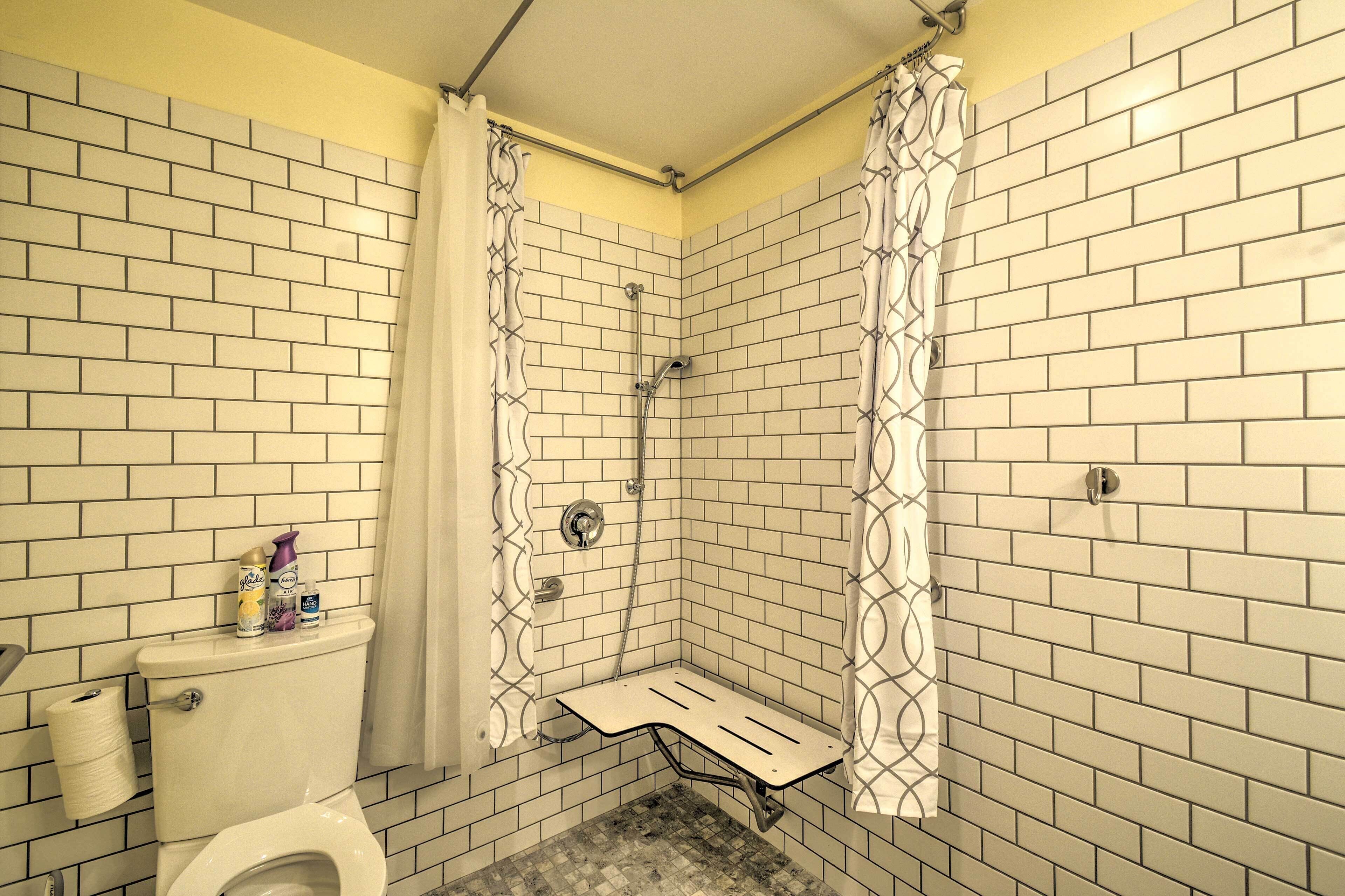 A small, enclosed shower area with a toilet and a shower bench.