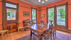 A dining room with a wooden table, chairs, and a chandelier.