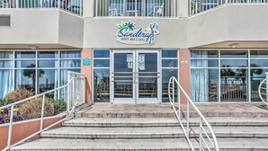 A building with a sign reading "Sandtrap Sports Bar & Grill" and a set of outdoor stairs leading to the entrance.