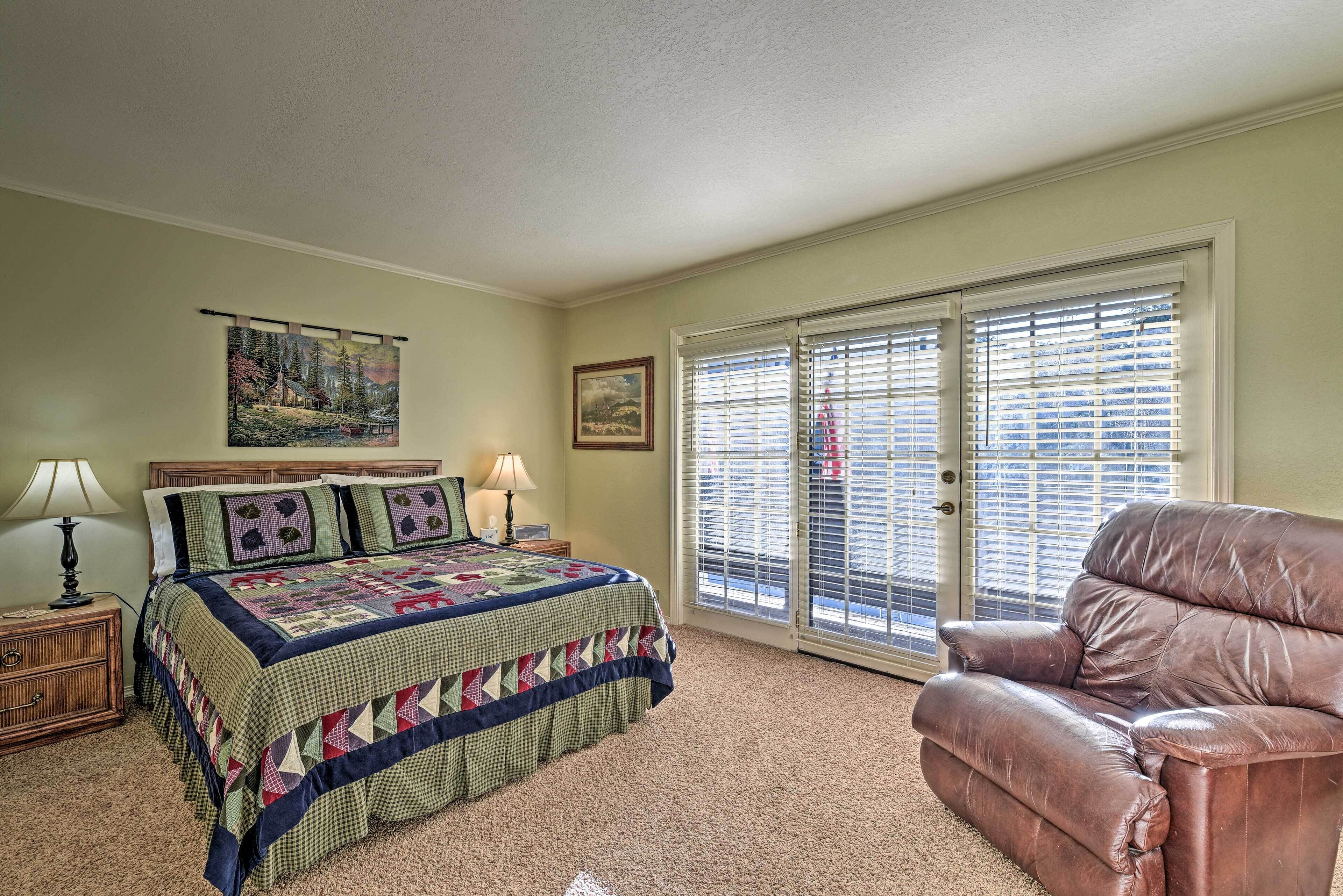 A bedroom with a bed, a chair, a nightstand, a lamp, and a painting on the wall.