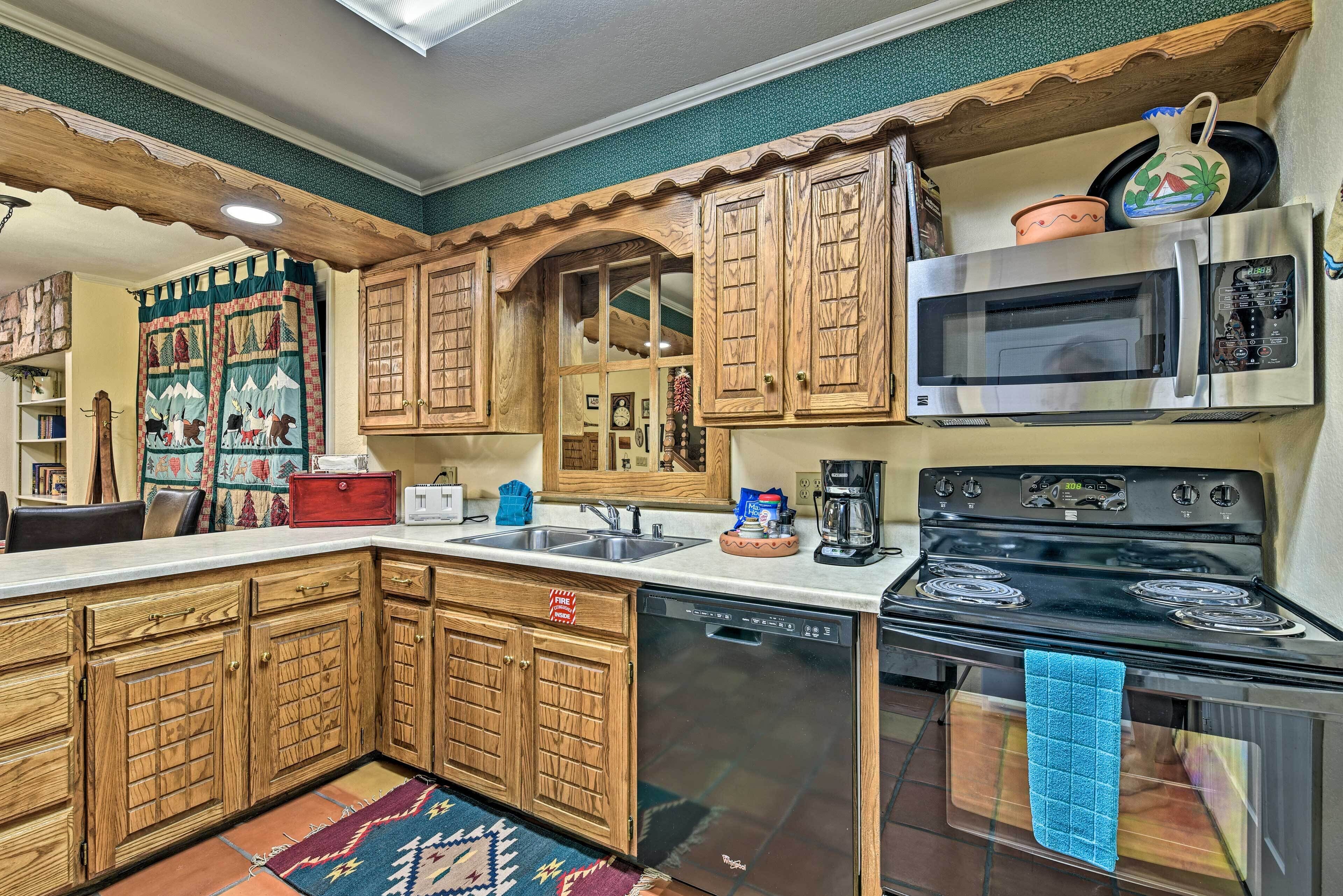 A kitchen with wooden cabinets, a dishwasher, a stove, and a microwave.