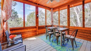 A wooden deck with a table and chairs, large windows, and a ceiling fan. - 'lakewood Secret' Cabin ~ 4 Mi to The Lake! (Canyon Lake)